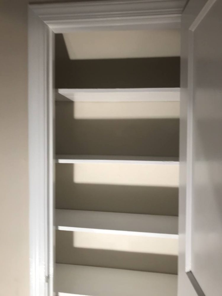 Closet shelving and hanging rods installed along a finished wall
