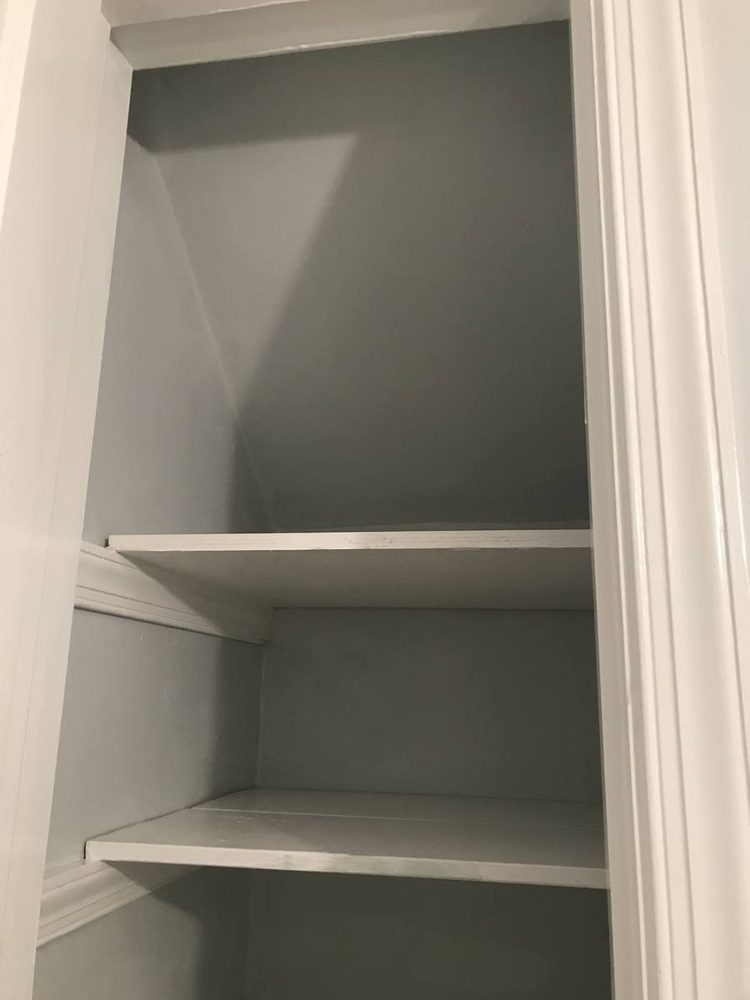 Closet shelving and hanging rods installed along a finished wall