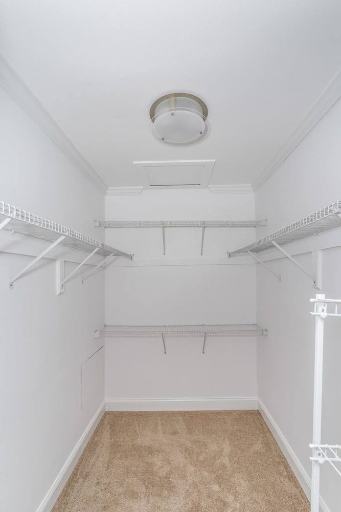 Closet shelving and hanging rods installed along a finished wall