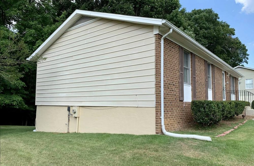 Exterior foundation and siding repainted on a residential home