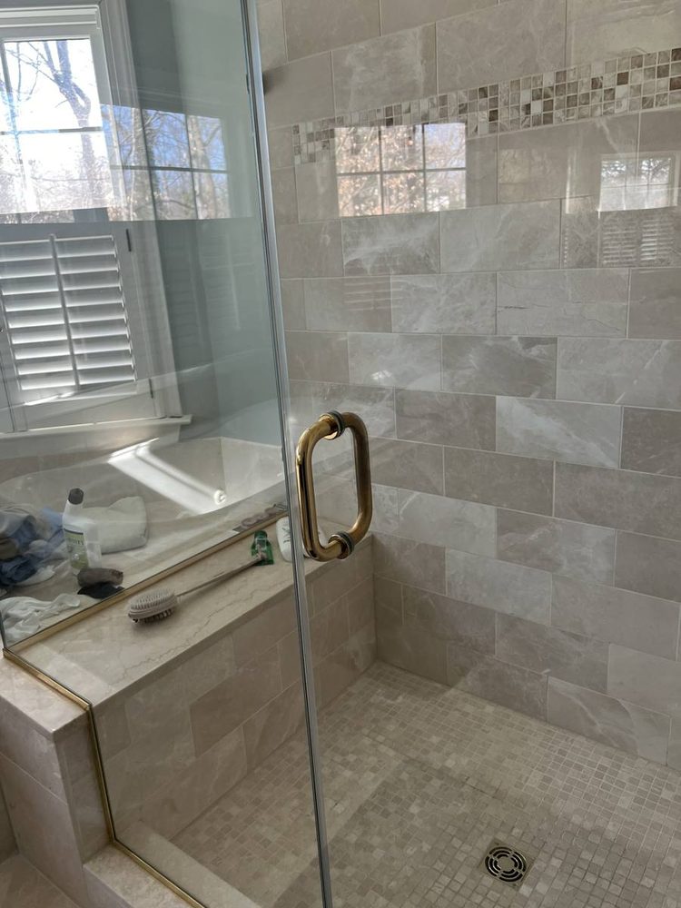 Glass shower door and enclosure fitted to a tiled shower