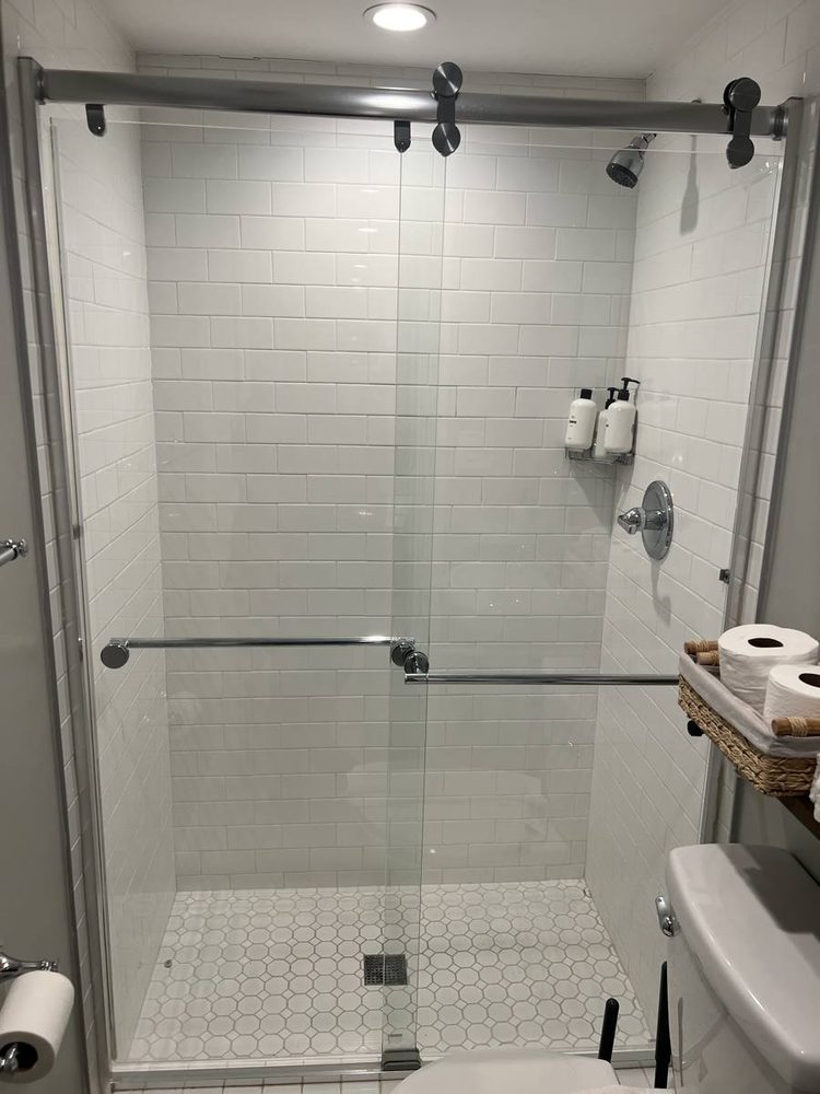 Glass shower door and enclosure fitted to a tiled shower