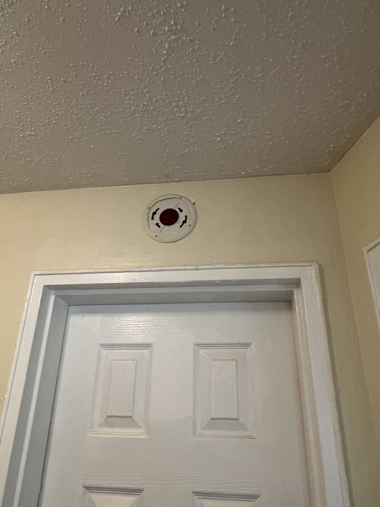 Smoke and carbon monoxide detector mounted to a ceiling, before the work